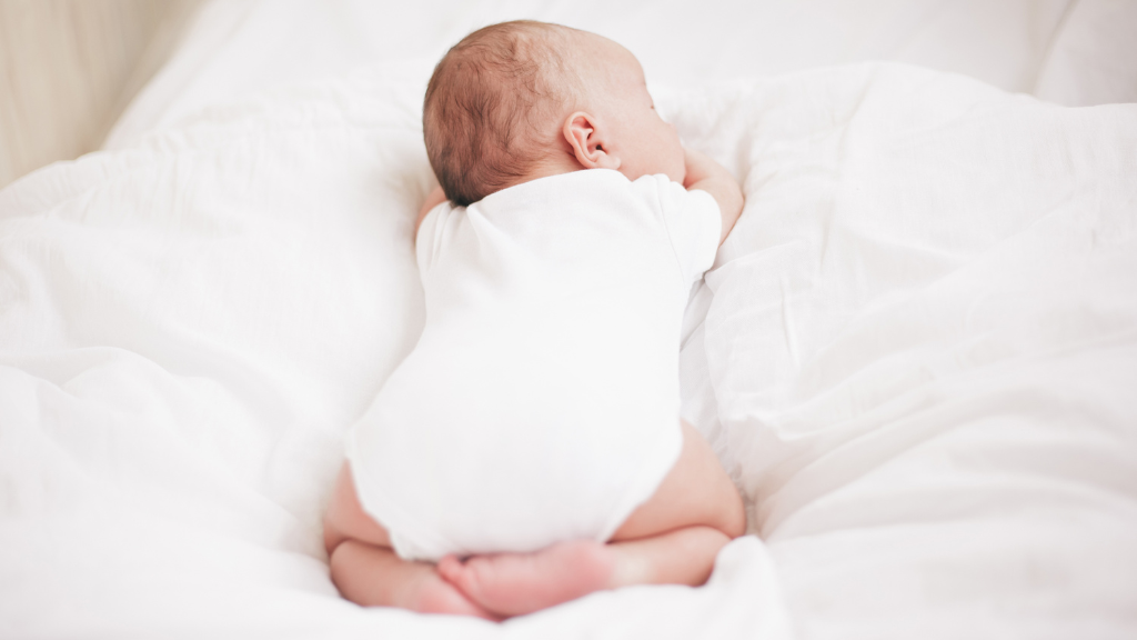 Baby auf weißer Decke als Titelbild für Artikel zu White Noise.