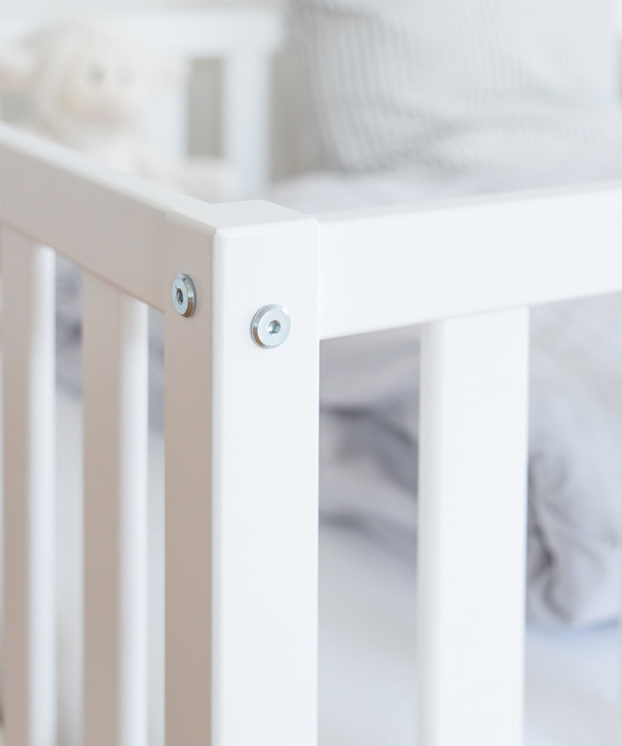 Hochwertiges Buchenholz*Unser Kinderbett wird aus nachhaltigem und massivem Buchenholz unter fairen Arbeitsbedingungen gefertigt.|Nahaufnahme Buchenholz in weiß.