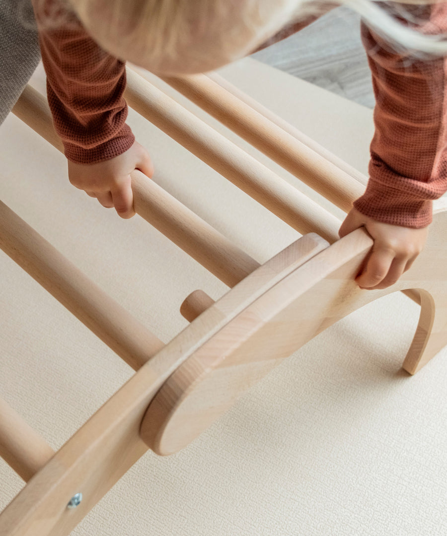 Kind klettert auf Montessori Kletterbogen.