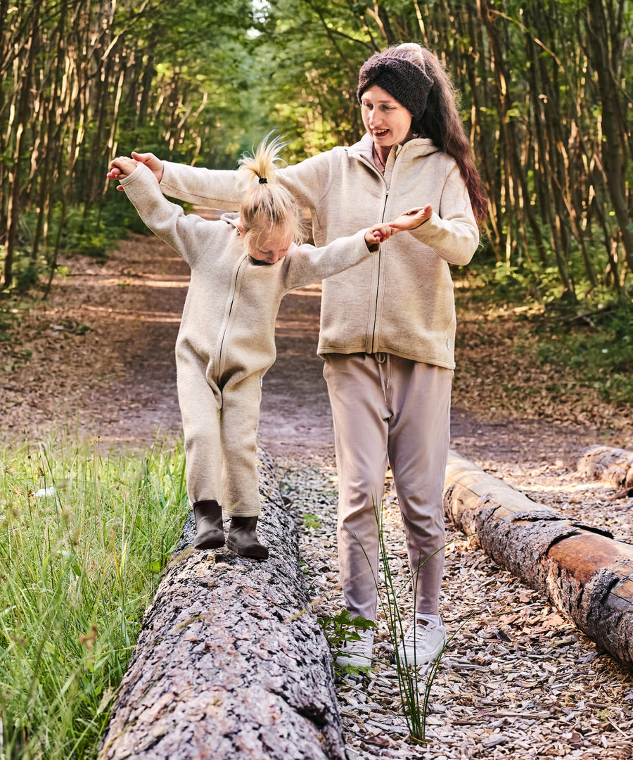 Freiheit bei jedem Schritt*Die Gummistiefel schenken Bewegungsfreiheit beim Spielen & Entdecken und stärken Muskulatur und Koordination.| Kind läuft mit den Barfußgummistiefeln auf einem Baumstamm im Wald.