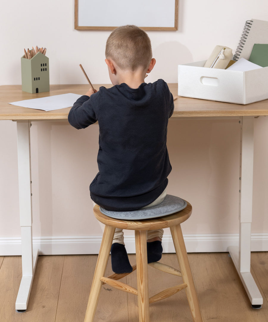 Bequemer durch den Alltag*Ob beim Malen, Spielen oder Essen: Die weiche Oberfläche macht das Sitzen auf Hocker, Bank oder Stuhl bequemer.|Kind sitzt beim  bequem auf einem weichen Sitzkissen.