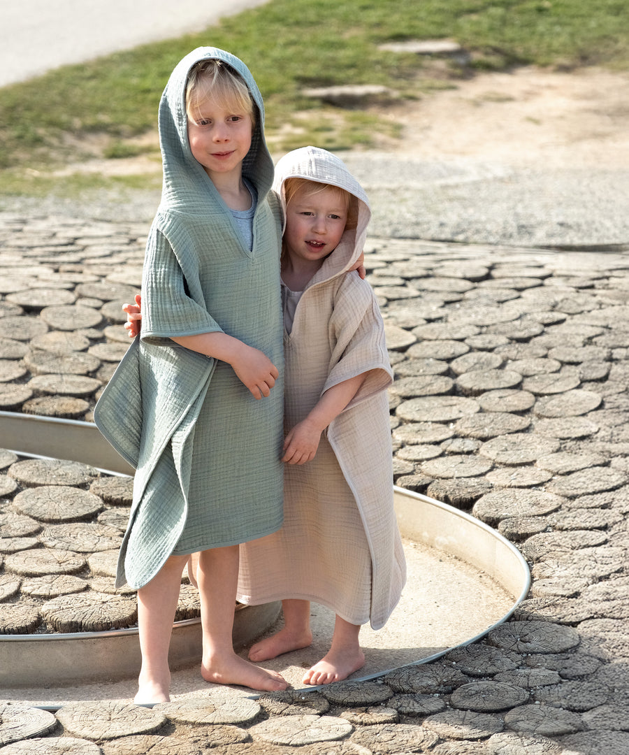 Schnell trocknend & pflegeleicht*Der Poncho trocknet nach dem Waschen besonders schnell und bleibt lange weich. Er ist maschinenwaschbar und nachhaltig produziert.|Kinder im Badeponcho aus Musselin.