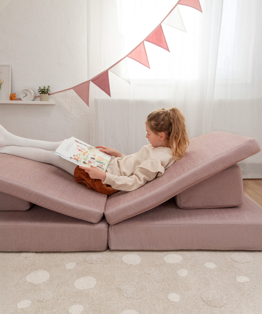 Das Hüpfsofa schafft eine kuschelige Leseecke im Kinderzimmer.