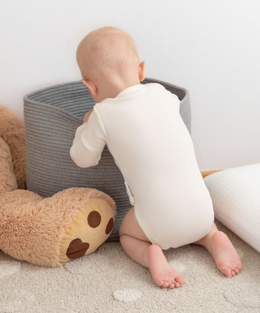 Baby holt etwas aus dem Aufbewahrungskorb.
