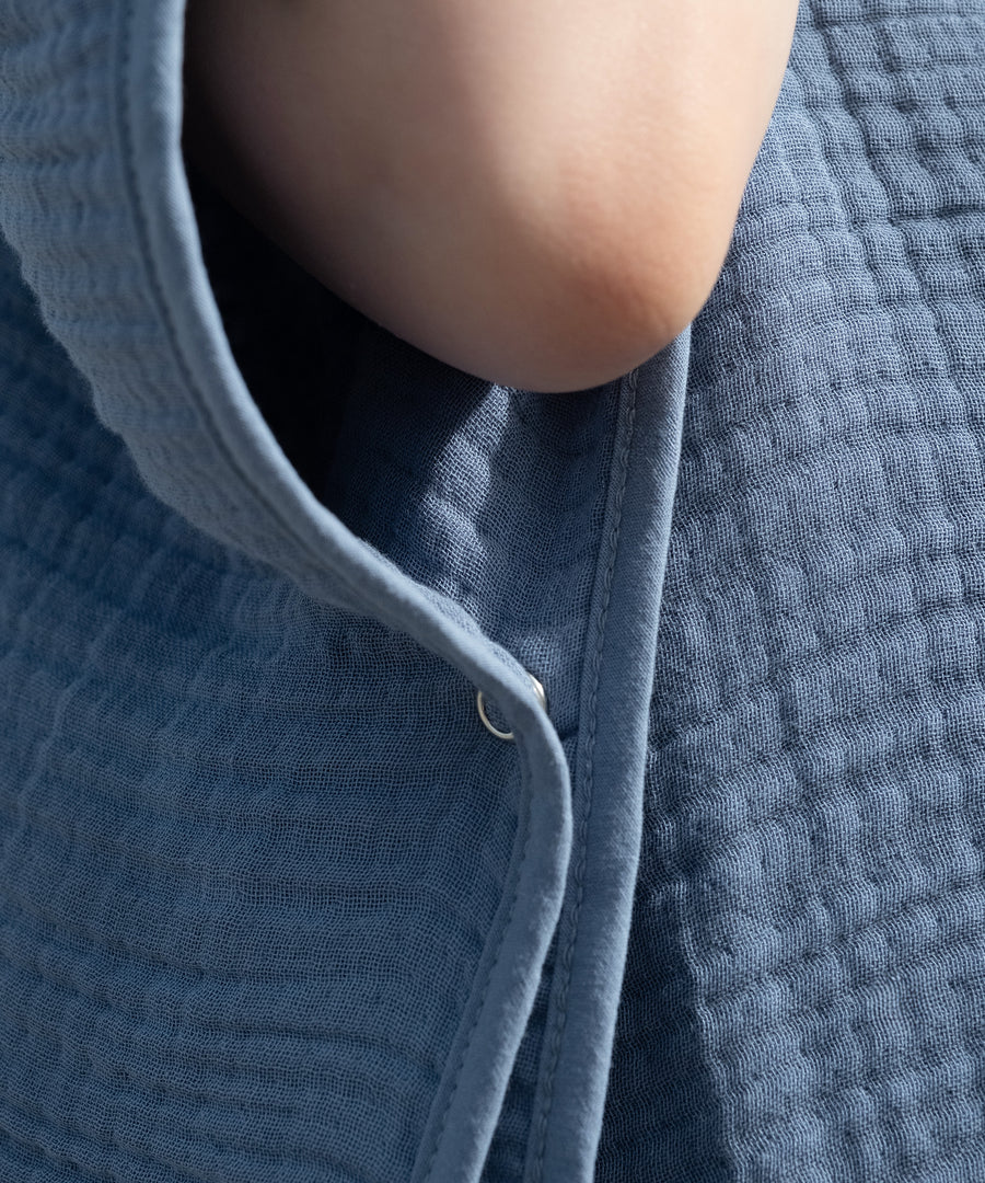 Sicherer Sitz mit Knopf*Ein seitlicher Druckknopf hält den Poncho sicher in Position. So bleibt dein Kind eingehüllt und kann sich trotzdem frei bewegen.|Druckknopf Detail Musselin Badeponcho.