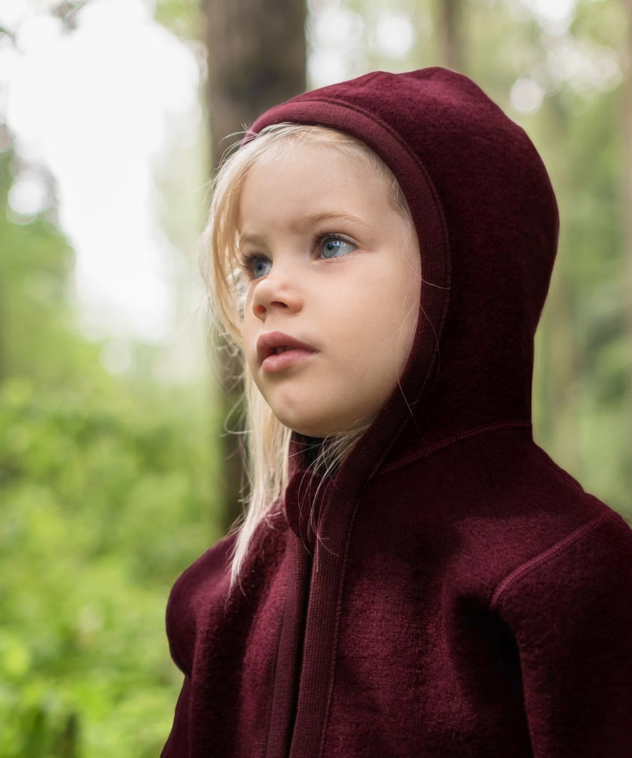 Nachhaltig & fair produziert*Die verwendete Bio-Schurwolle ist mulesing-frei und stammt aus artgerechter Tierhaltung. Walkjacke in Bordeaux.|Kind trägt Walkjacke in Bordeaux.