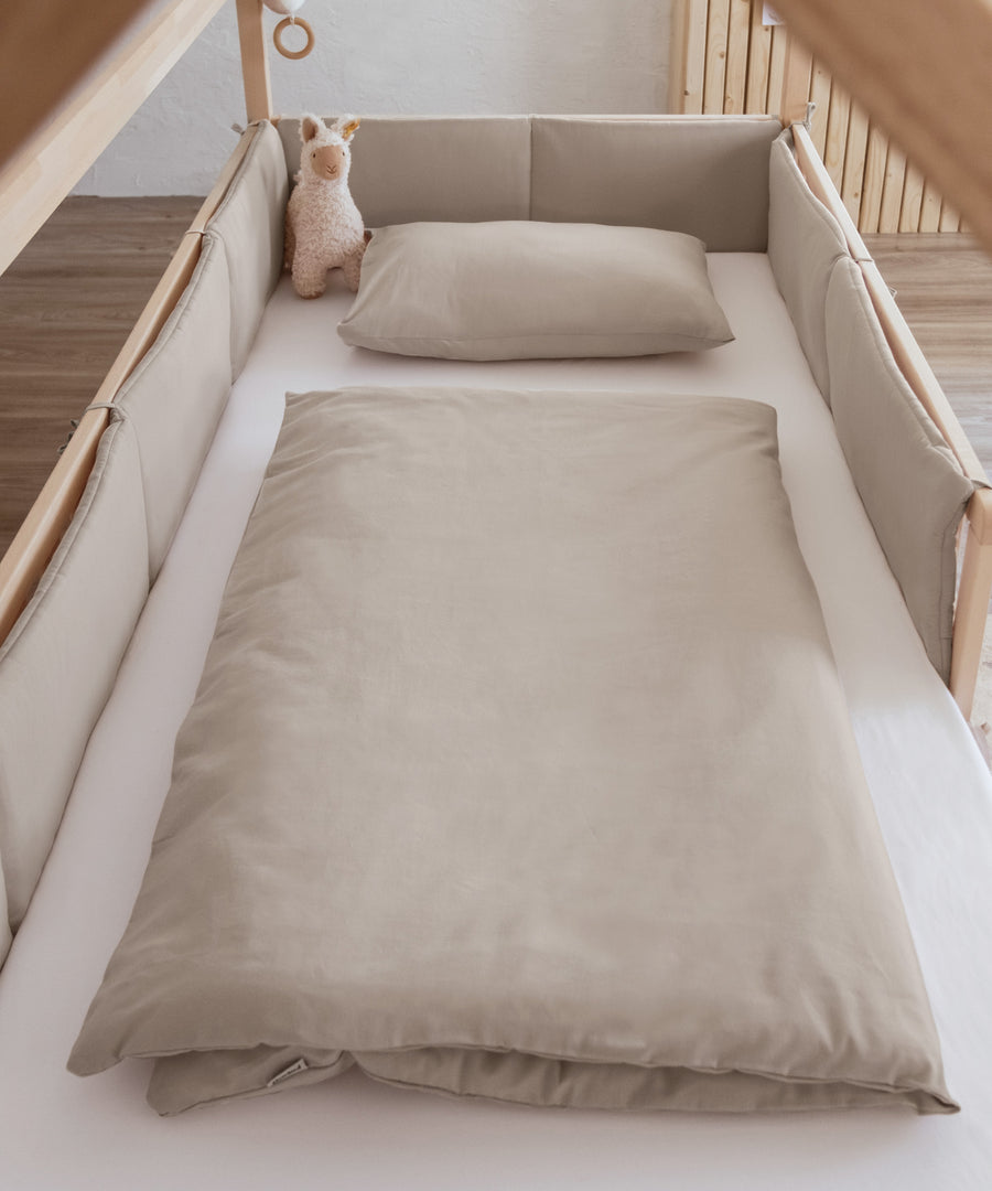 Bettumrandung und Bettwäsche in beige.